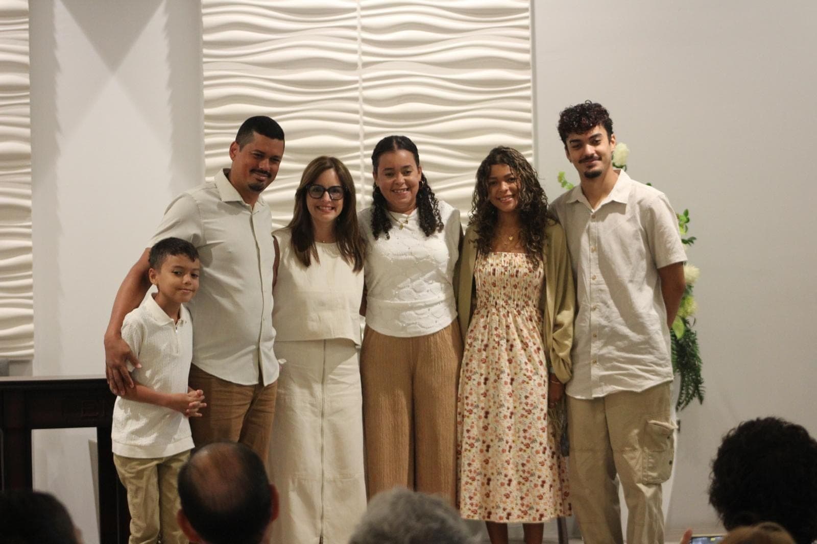 Familias y jóvenes posan juntos, sonriendo, junto al altar.