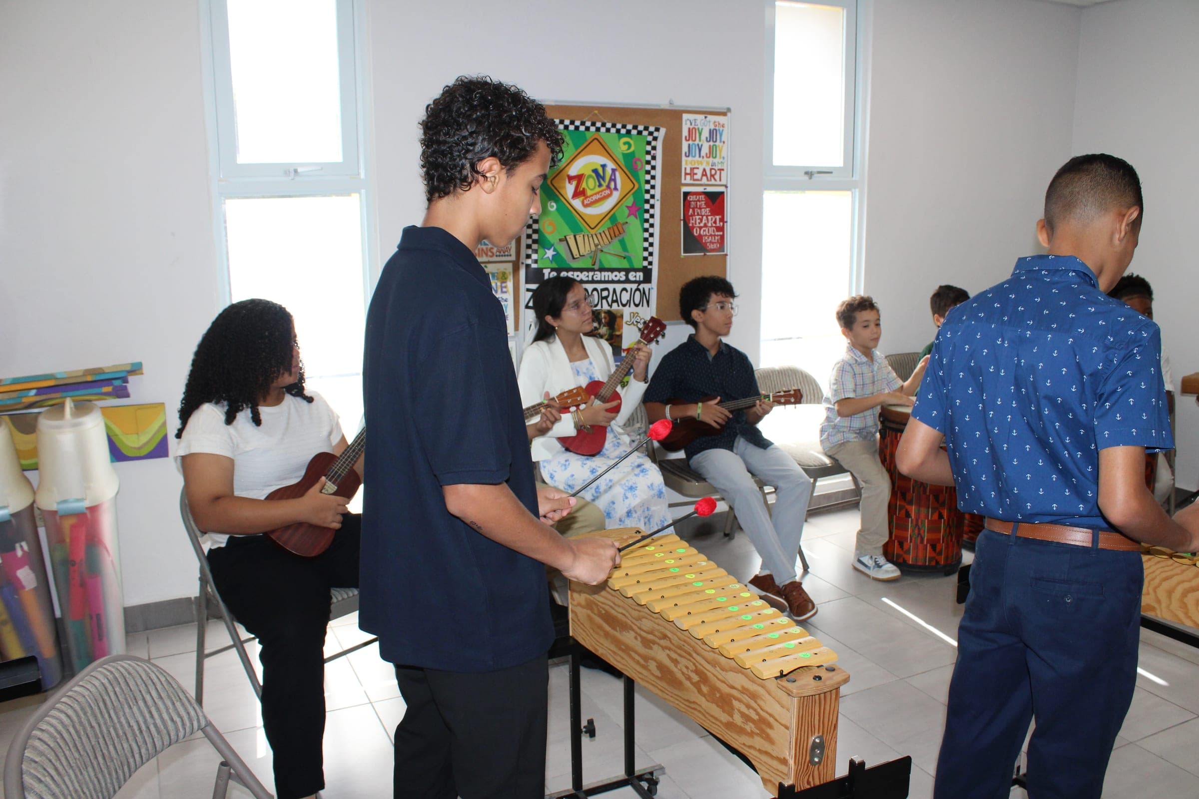 Niños y jóvenes tocando ukuleles y marimbas.